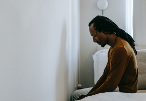 Man sitting on edge of bed looking at wall Can erectile dysfunction be cured